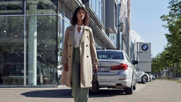 Femme devant un concessionnaire BMW BMW Serenity, femme devant un concessionnaire BMW