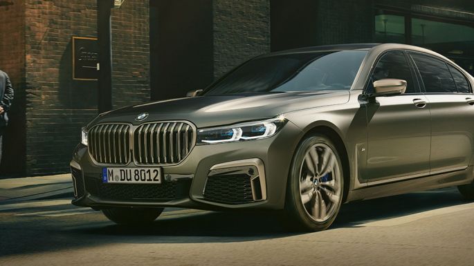 BMW M760Li xDrive Berline dans un décor urbain BMW M760Li xDrive Berline, se déplaçant sur une route dans un décor urbain, vue de profil de la partie avant du véhicule.