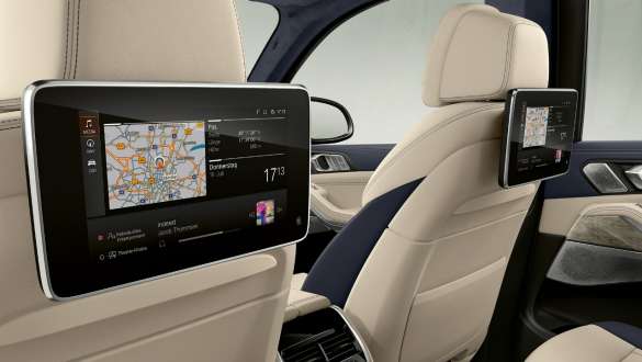 BMW X7 M avec système d’infodivertissement Professional aux places arrière BMW X7 M, habitacle, vue en diagonale sur le système d’infodivertissement Professional aux places arrière au dos des sièges avant, G07