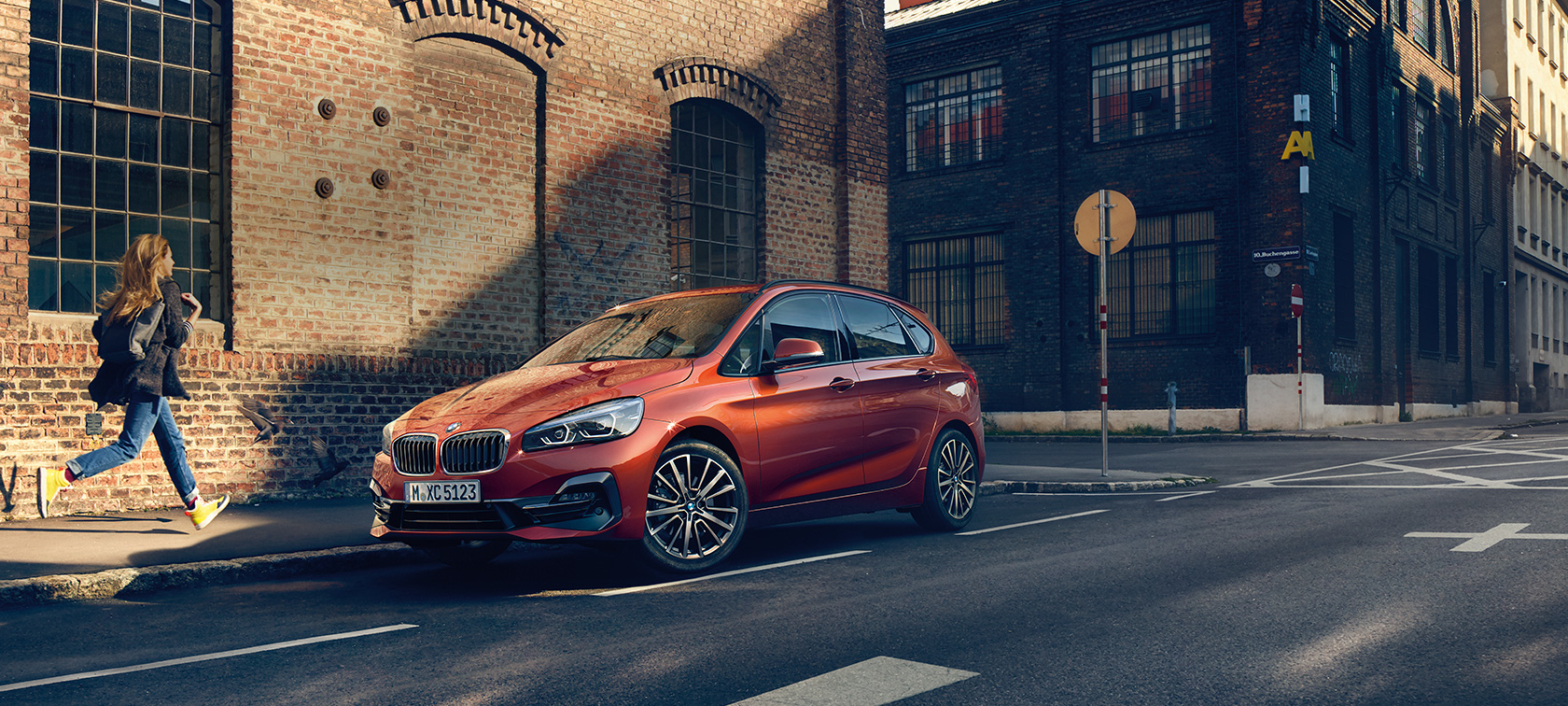 BMW Série 2 Active Tourer en stationnement BMW Série 2 Active Tourer F45 restylage 2018 Sunset Orange metallic, vue de trois quarts avant, en stationnement sur la route