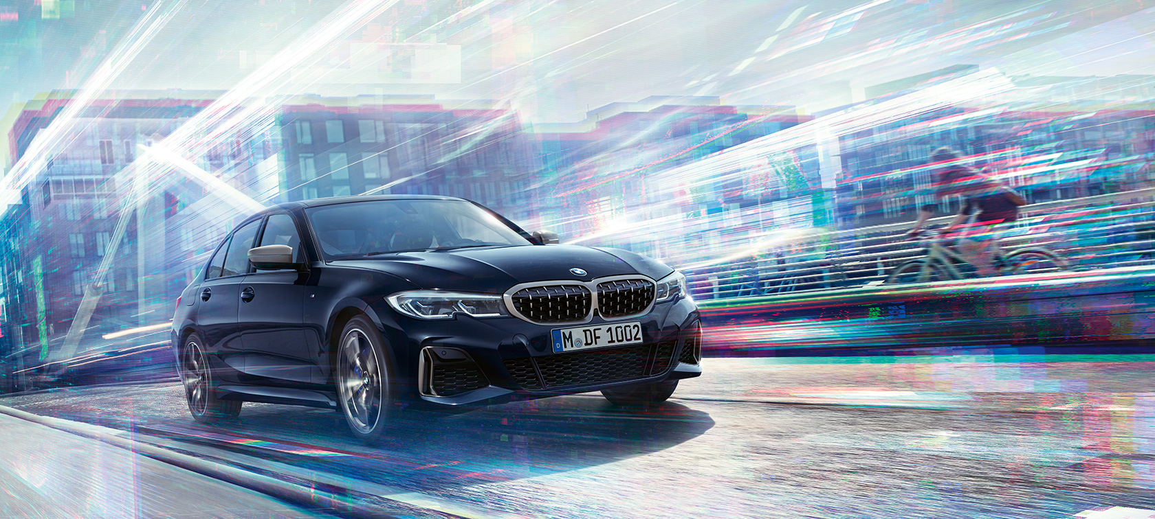 BMW Série 3 Berline, modèle M340i xDrive. Vue latérale de trois quarts BMW M340i xDrive roulant dans un décor urbain.