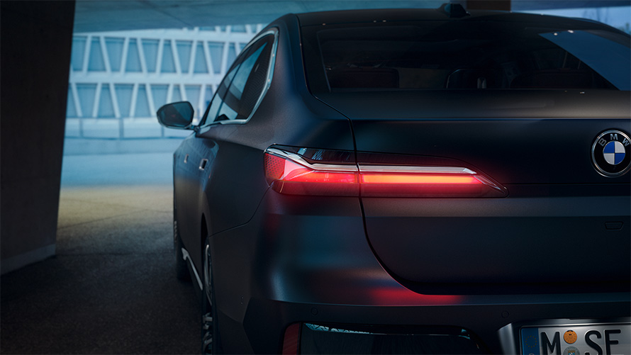 BMW Série 7 Berline G70 ICE 740d kit M Sport Frozen Deep Grey metallic vue arrière avec feu arrière rouge dans tunnel