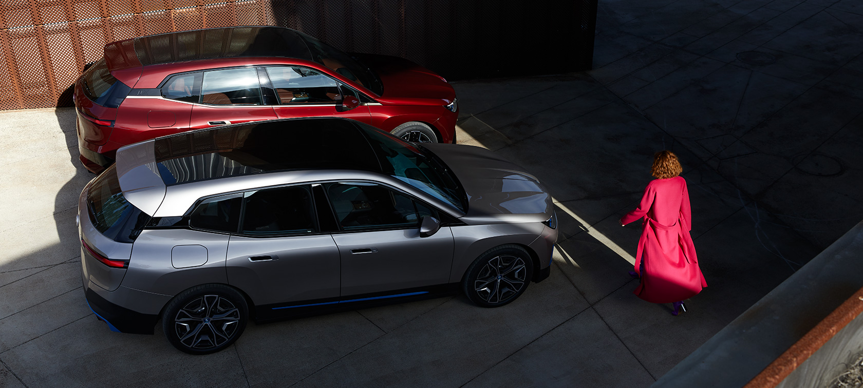 BMW iX, vue en plongée avec modèle BMW iX Aventurinrot et Karschmirsilber i20 vue en plongée avec modèle