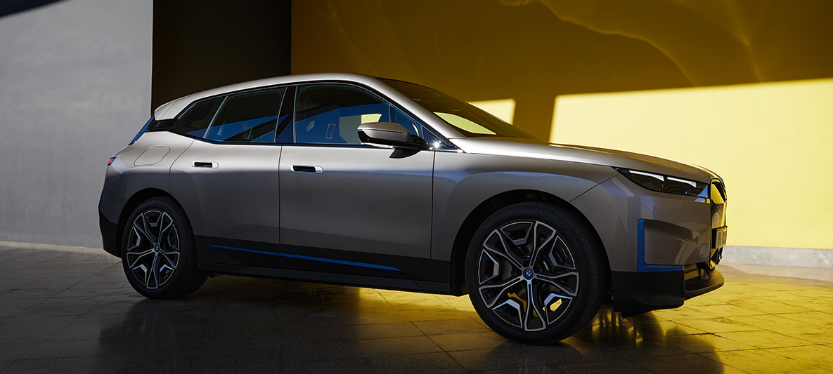 Vue de trois quarts de profil de la BMW iX, à l'arrêt Vue de trois quarts de profil de la BMW iX Kaschmirsilber i20, à l'arrêt