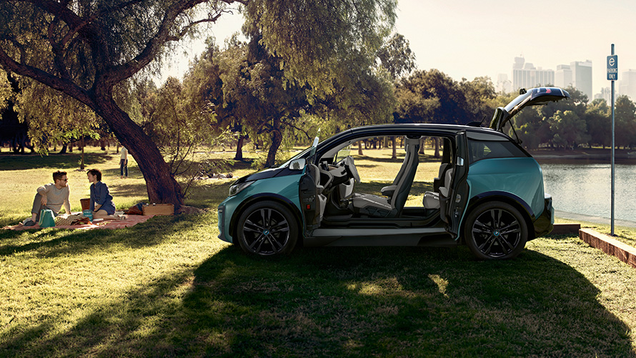 BMW i3 2018 dans le parc BMW i3 I01 2018 Jucarobeige avec accent Frozen Grey metallic vue latérale avec portes ouvertes dans le parc
