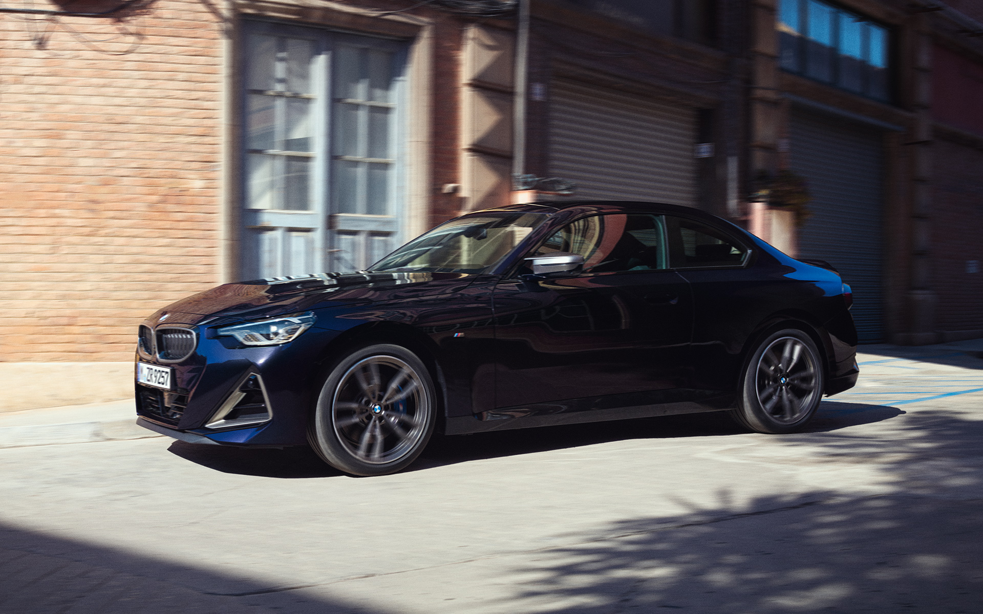 BMW M240i xDrive Coup&eacute; G42 2021 Black Sapphire metallic vue de profil devant entrep&ocirc;t de stockage