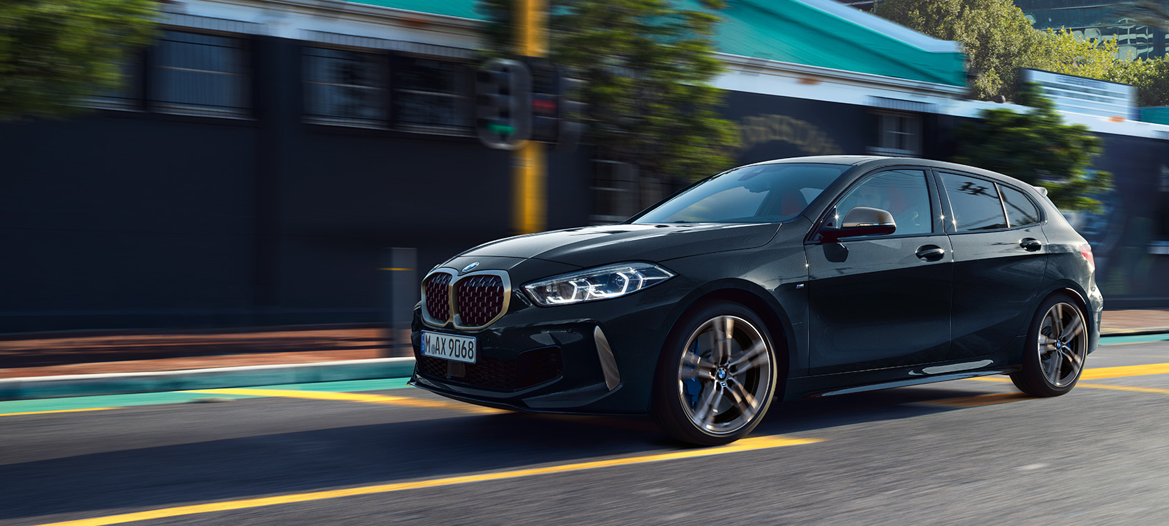BMW Série 1 M135i xDrive (F40) en Saphirschwarz metallic Voiture en mouvement dans un environnement urbain