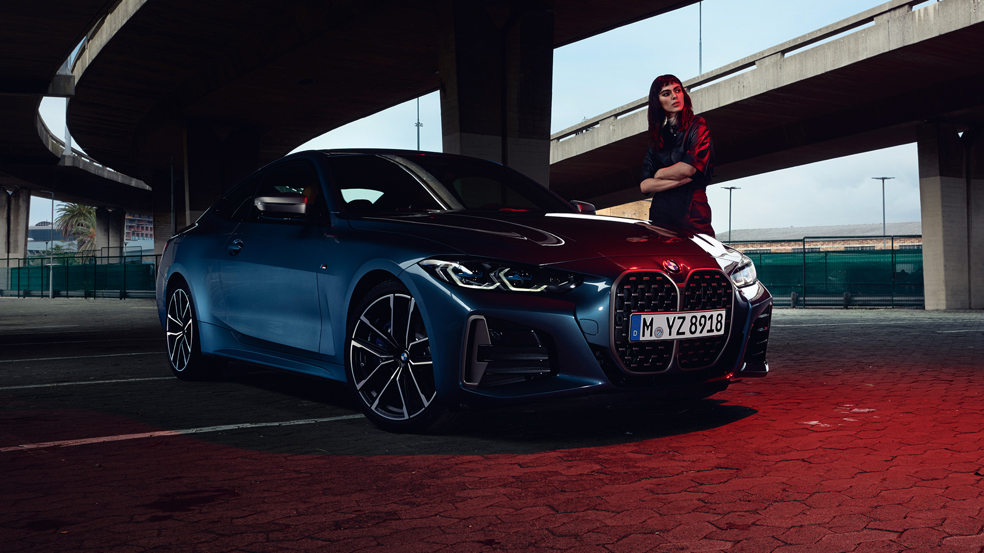 Modèle se tenant à côté de la BMW M440i xDrive Coupé G22 2020 vue de trois quarts de profil BMW M440i xDrive Coupé Arctic Race Blue metallic G22 2020 vue de trois quarts avant avec modèle