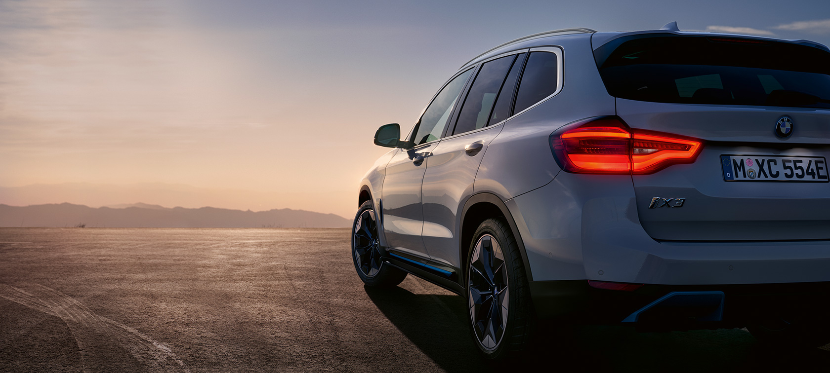 La BMW iX3 G08, à l'arrêt sur la route BMW iX3 G08 2020 en Mineralweiß metallic, vue de trois quarts arrière à l’arrêt, sur la route