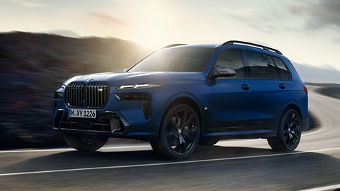 Modèles BMW X BMW X7 M G07 MP vue de trois quarts arrière en mouvement sur la route