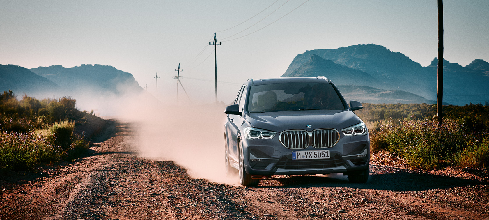 BMW X1, vue de trois quarts arrière. BMW X1, vue de trois quarts arrière devant le paysage montagneux.